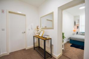 a bedroom with a bed and a table with a mirror at Stylish One-bedroom with Free Parking Sleeps 4 in Manchester