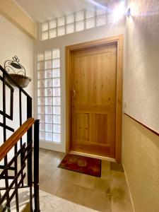 a hallway with a wooden door and a staircase at Guest House Baruffi in Carloforte