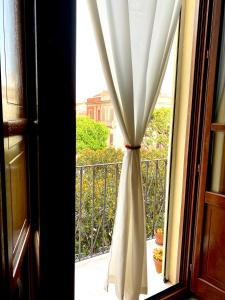 a window with a curtain on a balcony at Guest House Baruffi in Carloforte