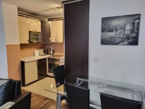 a small kitchen with a glass table and chairs at ZOGU Apartments - City Centre in Pristina +6 photos