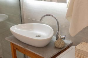 a white sink sitting on a counter in a bathroom at White Apartment in Kumbor