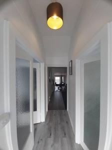 an empty hallway with a ceiling light and a hallway with at Zen Out on Surrey in Alfredton