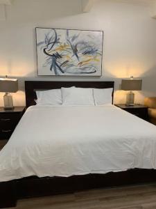 a bedroom with a large white bed with two lamps at Country studio pet friendly in Port Alberni