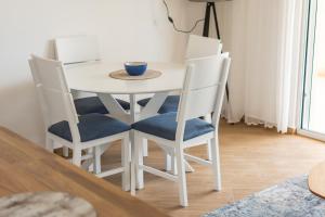 Biały stół z 4 krzesłami i miską na nim w obiekcie White Apartment w mieście Kumbor