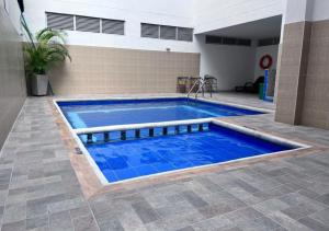 a swimming pool with blue water in a building at Hotel Caribe Rodadero in Santa Marta