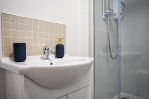 een badkamer met een wastafel en een douche bij Stylish One-bedroom with Free Parking Sleeps 4 in Manchester