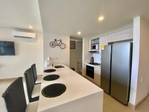 a kitchen with a white counter and a refrigerator at Espectacular frente al Mar- Morros Zoe - Playa Manzanillo Cartagena in Cartagena de Indias