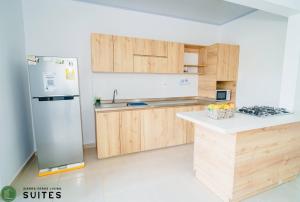 a kitchen with wooden cabinets and a stainless steel refrigerator at Sierra Verde Living 2 in Apartadó