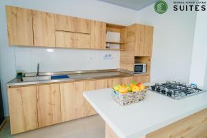 a kitchen with wooden cabinets and a basket of fruit at Sierra Verde Living 2 in Apartadó