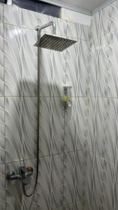y baño con ducha con cabezal de ducha. en Tapian Ratu Camp en Bukittinggi