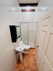 a white bathroom with a toilet and a sink at Villa Bonita Los Naranjos in Los Naranjos