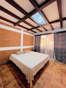 1 dormitorio con 1 cama grande en una pared de ladrillo en Villa Bonita Los Naranjos, en Los Naranjos