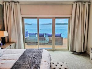 a bedroom with a large window with a view of the ocean at Magazine-Featured Mansion, Golf Green, Casino, etc in Sunrise Beach