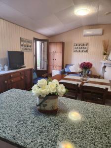 ein Wohnzimmer mit einem Tisch und einer Blumenvase in der Unterkunft Tertium house in Telti