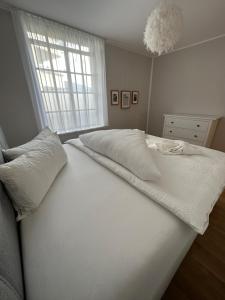 un letto bianco in una stanza con finestra di Bodensee Loft in Strandnähe a Lochau