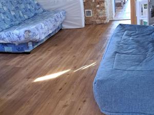 a living room with a blue couch and a wooden floor at Gîte Ruillé-sur-Loir, 4 pièces, 8 personnes - FR-1-410-134 in Ruillé-sur-Loir