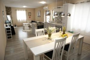 a kitchen and living room with a white table and chairs at Apartment Tina in Vodice
