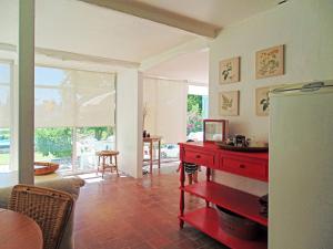 sala de estar con mesa roja y cocina en Casa Lago Rapel, en Las Cabras