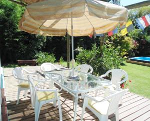 una mesa y sillas bajo una sombrilla en una cubierta en Casa Lago Rapel, en Las Cabras