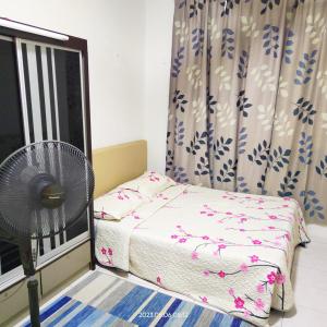 a small bedroom with a bed and a fan at Homestay Kasturi Teluk Kalong Kemaman in Kijal