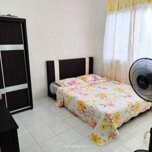 a bedroom with a bed and a fan at Homestay Kasturi Teluk Kalong Kemaman in Kijal
