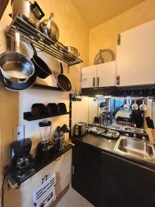 a kitchen with a sink and a counter with pots and pans at The International Cozy Inn in New York
