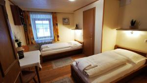 um pequeno quarto com 2 camas e uma janela em Gasthof Geronimo em Weissbach bei Lofer
