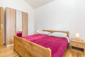 - une chambre avec un grand lit et une couverture rouge dans l'établissement Villa Oasis near Krka Waterfalls, à Drniš
