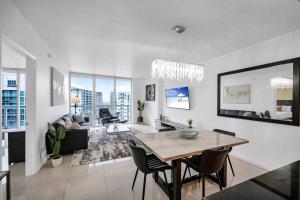 Una sala de estar blanca con una mesa y sillas. en 38th floor W residence with amenities, en Miami
