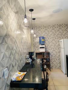 a kitchen with a black counter and a refrigerator at Flat Milagres Bontempo in São Miguel dos Milagres +21 photos