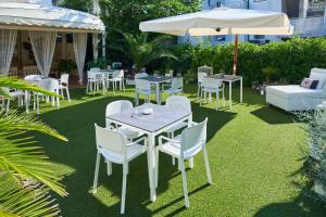 a patio with tables and chairs and an umbrella at Hotel Bruna B&B in Milano Marittima