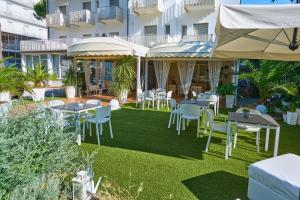 a patio with tables and chairs and a building at Hotel Bruna B&B in Milano Marittima