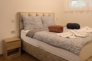 uma cama com duas almofadas e toalhas em GOLDEN VIEW Sokobanja em Sokobanja