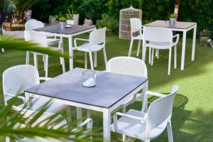 un groupe de tables et de chaises sur l'herbe dans l'établissement Hotel Bruna B&B, à Milano Marittima