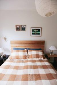 a bedroom with a bed with a striped blanket and two lamps at Bluey in Warrnambool