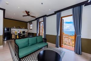 富国SUNSET BAY RETREAT的带绿色沙发的客厅和厨房