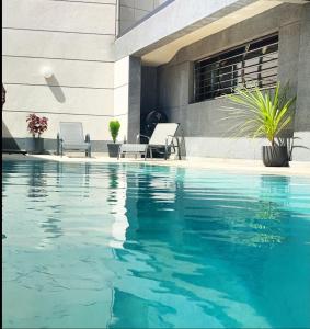 a swimming pool with two chairs next to a building at Villa piscine sans vis à vis vue mer in Tangier