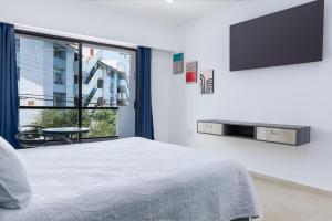 1 dormitorio con 1 cama y TV de pantalla plana en Casa Xtao Hotel, en Santa Cruz Huatulco