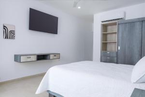 a bedroom with a bed and a tv on a wall at Casa Xtao Hotel in Santa Cruz Huatulco