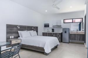 a bedroom with a large bed and a kitchen at Casa Xtao Hotel in Santa Cruz Huatulco