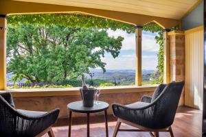 a porch with chairs and a table and a large window at Mount Lofty House in Adelaide