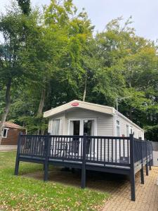 a mobile home with a porch and a fence at 16 Leaf Lane Country Retreat in Newton on the Moor