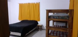 ein Schlafzimmer mit einem Etagenbett und einem gelben Vorhang in der Unterkunft Monoambiente Caffe PB in Guaymallen