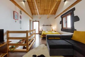 a living room with a couch and a bed at Casas da Pedreira in Lajes do Pico