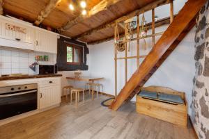una cocina con armarios blancos y una mesa con sillas. en Casas da Pedreira, en Lajes do Pico