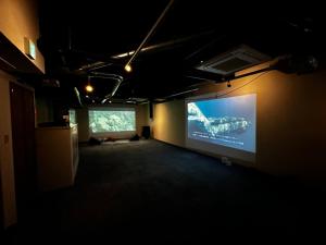 a dark room with a projection screen on the wall at Artist Village Apartments Kochi in Kochi