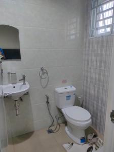 uma casa de banho com um WC e um lavatório em DULLI TRANSIENT HOUSE em Lipa