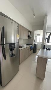 een grote keuken met een roestvrijstalen koelkast bij Cómodo y familiar apartamento en Niquia in Bello