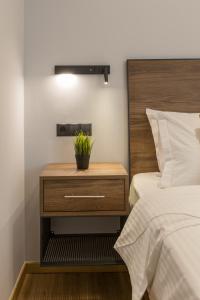 a nightstand with a plant on it next to a bed at Aethir Urban Stay by Raise in Athens