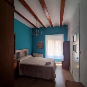 sypialnia z łóżkiem i niebieską ścianą w obiekcie CASA RURAL ALEGRÍA w mieście Caudete de las Fuentes